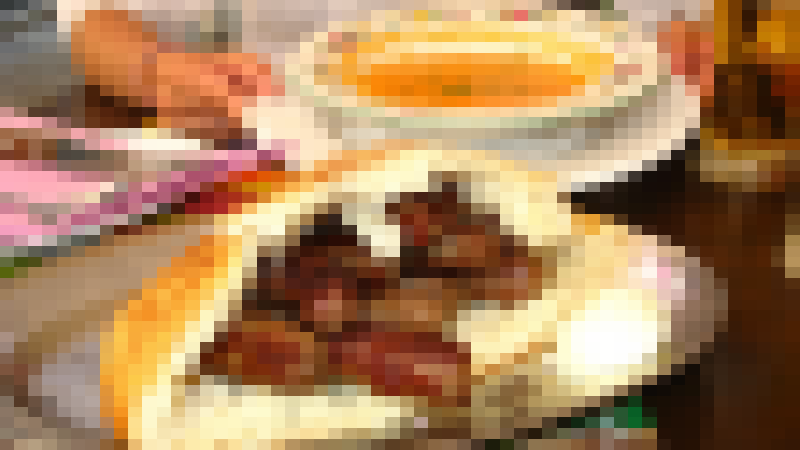 A shared plate of ćevapi arrives at a Bosnian table